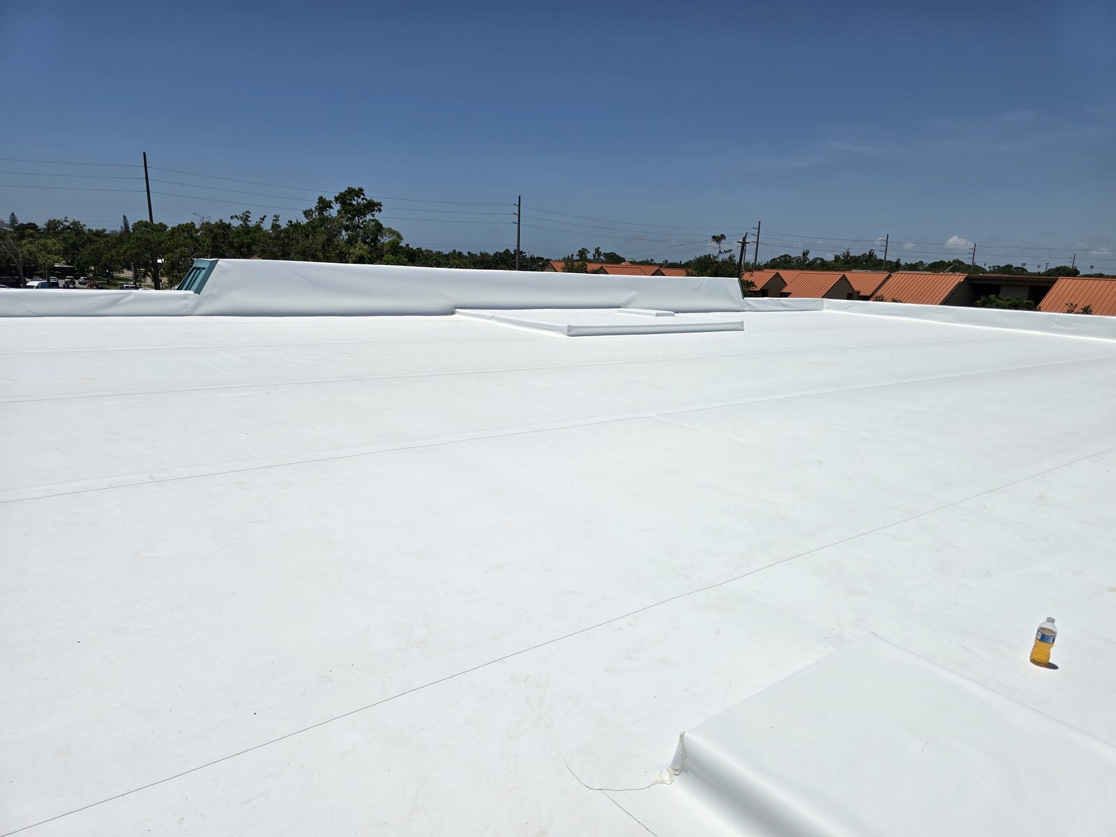 Bright white reflective coating covering a commercial flat roof after restoration